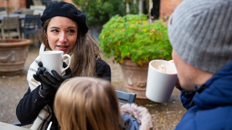 A couple enjoy hot drinks sitting in the courtyard outside Felbrigg's Squire's Pantry.